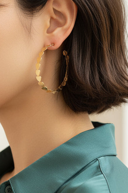 Close-up of a beautiful woman wearing gold hoop earrings with a blurred beautiful home
 background
